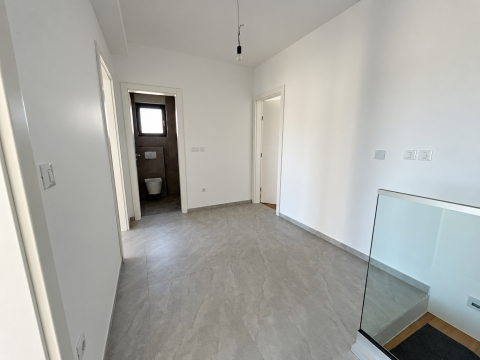 original_1790936366_minimalist-gray-tiled-hallway-with-glass-railing.png