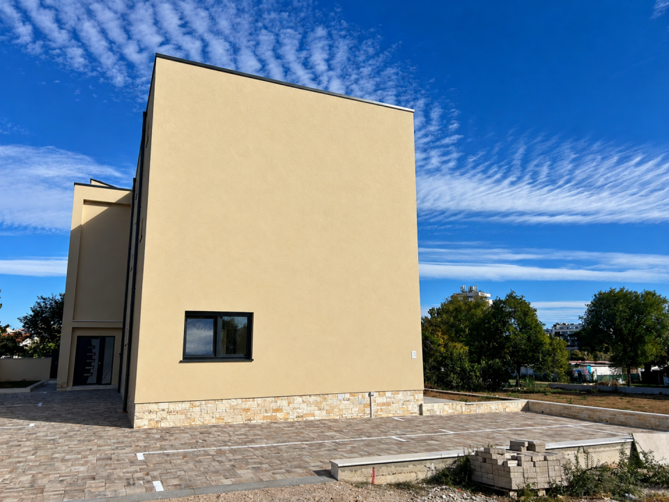 original_1792006971_modern-beige-stucco-building-under-streaked-skies.png